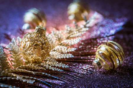 Christmas ornaments and balls with glitter background in violet and golden tones. Selective focus.の写真素材