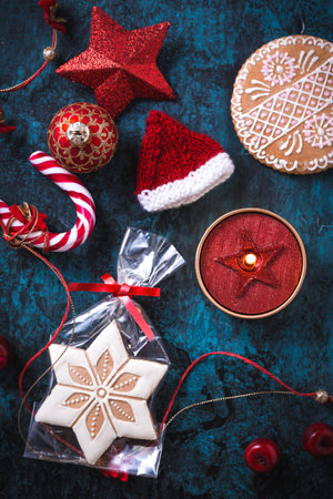 Christmas candle with gingerbread cookies, decorations and ornament on blue backgroundの写真素材