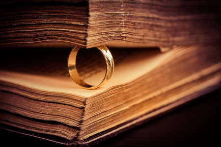 Golden ring between the pages of old book in vintage style, close up, soft focusの写真素材