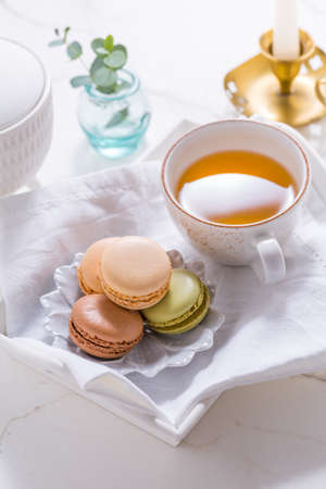 Macarons dessert and cup of tea on white tableの写真素材