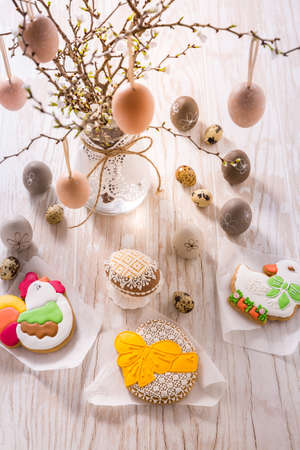 Easter decoration with homemade Easter gingerbread cookies on wooden tableの写真素材