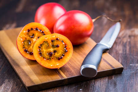 Organic tamarillo (tree tomato, Solanum betaceum) on cutting boardの写真素材