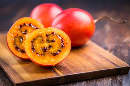 Organic tamarillo (tree tomato, Solanum betaceum) on cutting boardの写真素材