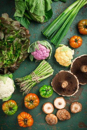 Assortment of organic vegetables and edible mushrooms on green backgroundの写真素材
