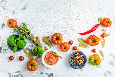Assortment of organic tomatoes, spices and herbs on kitchen tableの写真素材