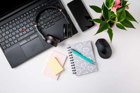 Workplace and office desk with laptop, headset and smarthpone. Flatlay on white background.の写真素材