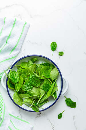 Organic raw spinach in bowl on white backgroundの写真素材