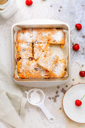 Homemade cherry sponge cake with chocolate drops with ingredientsの写真素材