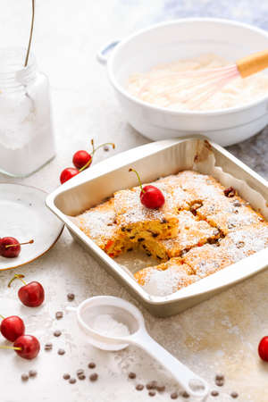 Homemade cherry sponge cake with chocolate drops with ingredientsの写真素材