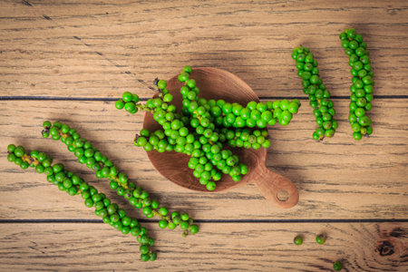 Fresh green peppercorns on wooden kitchen table.の写真素材