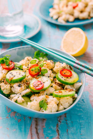 Asian salad with roasted cauliflower, cucumber, onion and chiliの写真素材
