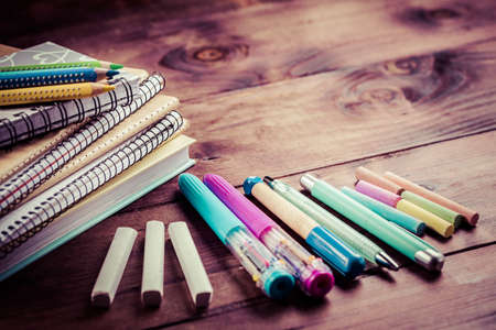 School supplies with exercise book and notepads on wooden background. Back to school concept.の写真素材