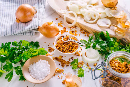 Making homemade fried onions with ingredients on white kitchen tableの写真素材