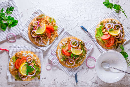 Greek gyros meat with pita flat bread, vegetables and onions and Tzatziki dip on white backgroundの写真素材