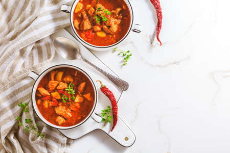 Beef goulash soup - hearty Hungarian soup of meat and vegetables seasoned with paprika on white backgroundの写真素材
