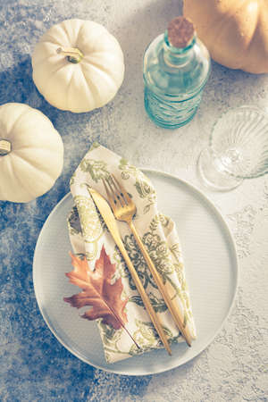 Place setting for Thanksgiving in vintage style with pumpkins and autumn leafの写真素材