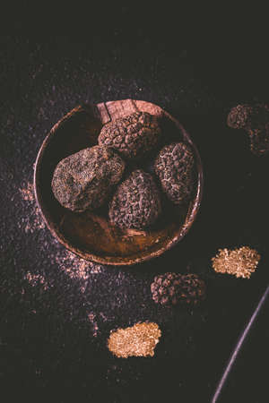 Black truffle in bowl on dark background, cooking delicacyの写真素材