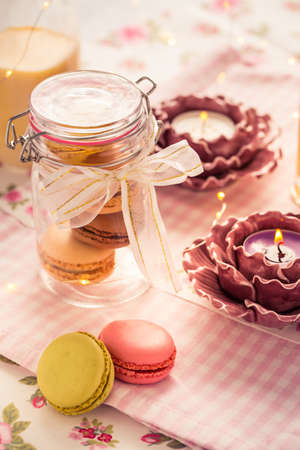 Sweet French macarons in cookie box with candles in vintage styleの写真素材