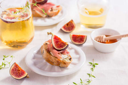 Small canape snack, crostini with ham, fig and apple wine, Italian antipastiの写真素材