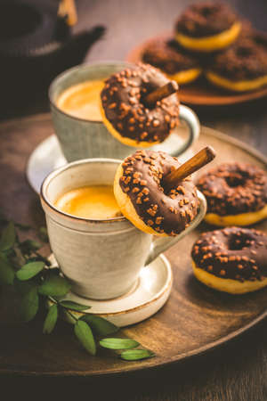 Two cups of Caffe Americano with small chocolate donutsの写真素材