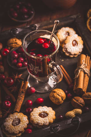 Mulled wine with cranberry and spices, Christmas cookies and candlesの写真素材