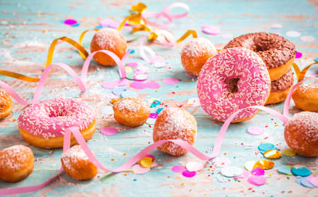 Krapfen, Berliner and donuts with streamers and confetti. Colorful carnival, birthday and Fasching imageの写真素材