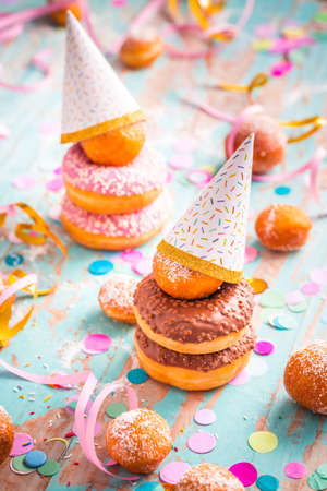 Krapfen, Berliner and donuts with streamers and confetti. Colorful carnival, birthday and Fasching imageの写真素材