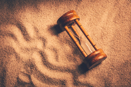 Old sandtimer in sand in vitange look. Concept of time, age and historyの写真素材