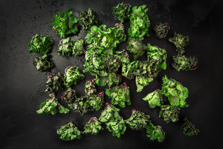 Kalette, kale sprouts or flower sprouts on black background. Hybrid plant, cross between kale and...