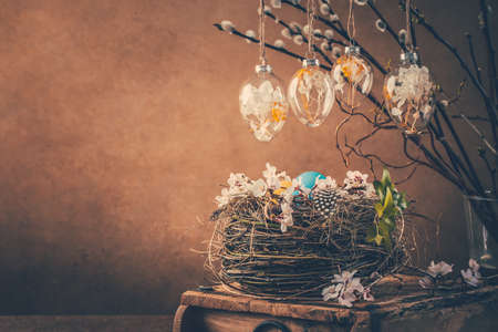 Nest with Easter eggs and blooming branches with pussy willow branches decorated  in vintage styleの写真素材