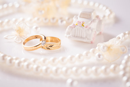 Wedding still life with golden rings and pearl necklace in whiteの写真素材
