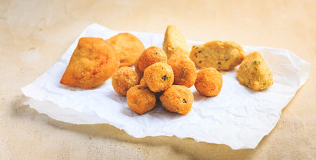 Finger food and street food - assortment of Arancini rice balls, fried curd balls, cod pies