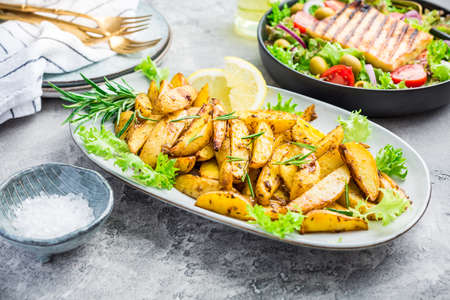 Potato wedges, oven roasted with freshly mixed salad and grilled cheeseの写真素材