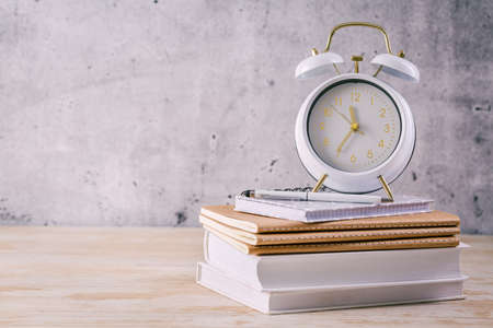Time managament concept for schoolers and students. Books with clockの写真素材