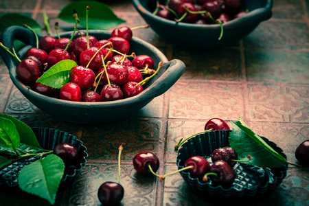 Fresh raw organic sour cherry in bowl on kitchen tableの写真素材