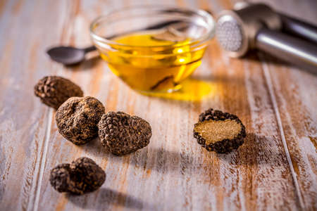 Truffle mushroom oil on wooden background. Gourmet food.の写真素材