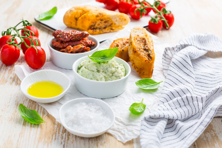 Avocado spread and sun dried tomatoes with olive oil as antipasto and baguetteの写真素材