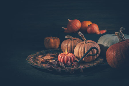 Autumn or fall harvest concept with pumpkins and candles on dark wooden backgroundの写真素材