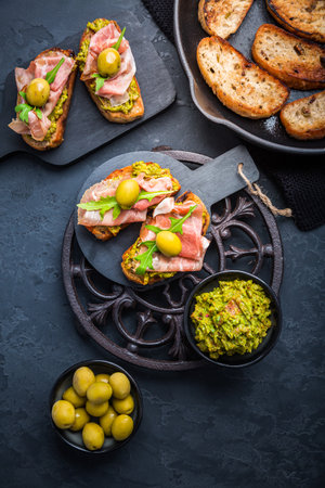Delicious crostini with avocado spread and serrano or prosciutto hamの写真素材