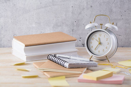 Alarm clock and books - time management and procrastination conceptの写真素材