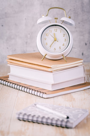 Alarm clock and books - time management and procrastination conceptの写真素材