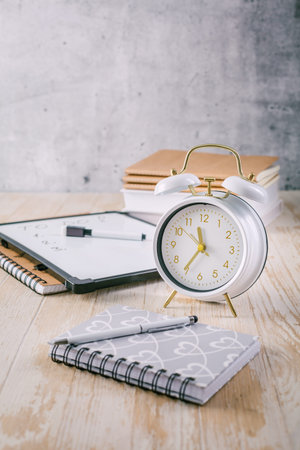 Alarm clock and books - time management and procrastination concept