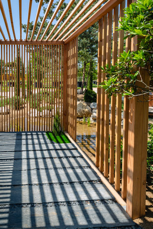 Modern wooden arbor. Modern wooden gazebo in courtyard, backyard. Urban gazebo, relaxing garden design.の写真素材
