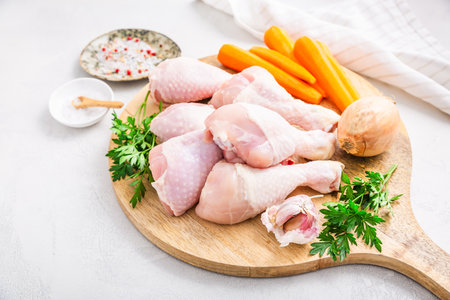 Raw chicken drumsticks with vegetables ans spices prepared for cookingの写真素材