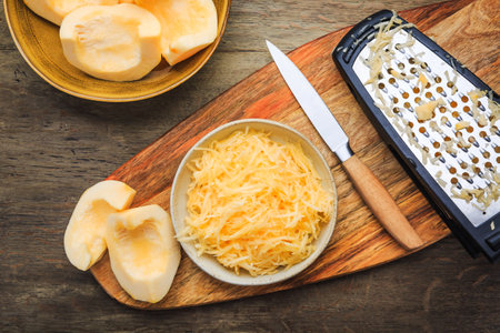 Peeled and grated yellow zucchini or pumpkin, prepared for cookingの写真素材