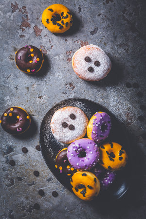 Halloween donuts and Berliners with assorted frosting and sugar sprinkles for Halloween and carnivalの写真素材