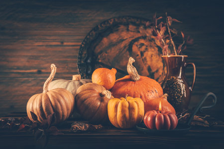 Autumn still life with pumpkins and candles on wooden background. Thanksgiving home decoration.の写真素材