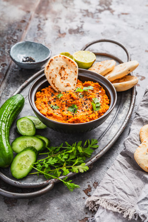 Homemade vegan Harissa carrot and lentil spread or dip with flatbread and cucumberの写真素材