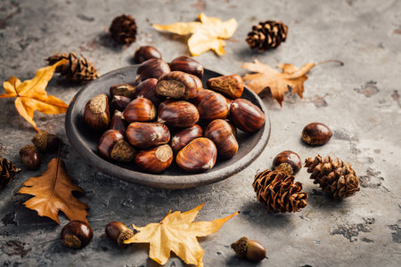 Organic sweet chestnuts in a bowl on kitchen table, prepared for baking or cookingの写真素材