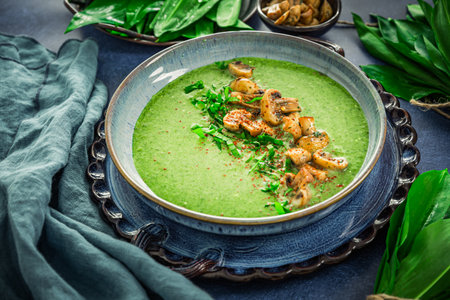 Creamy homemade bear leek soup or ramson soup with fried mushroomsの写真素材